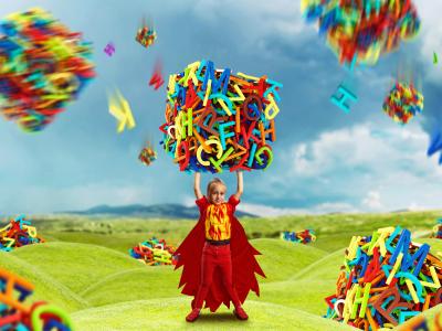 Barn holder en stor kasse lavet af bogstaver i begge hænder over hovedet